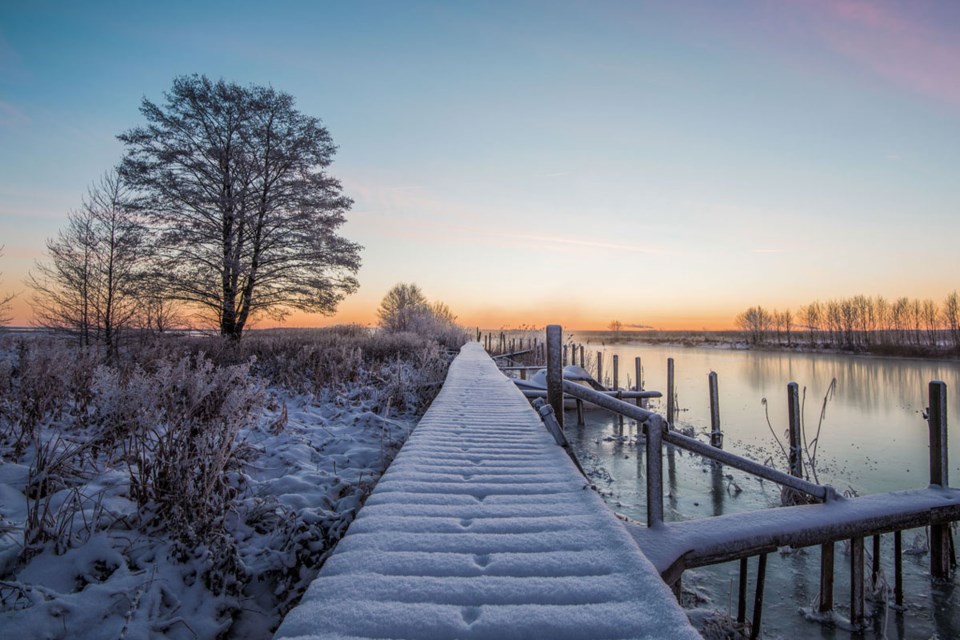 Snødekket brygge ved solnedgang
