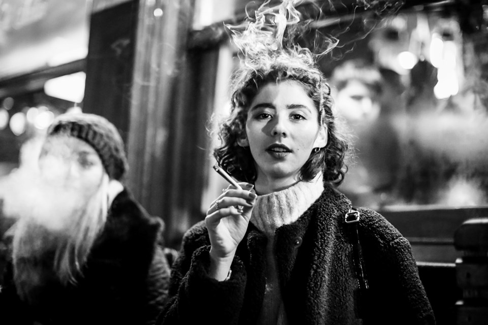 Svart-hvitt-bilde av en kvinne som røyker. Foto: Mats Alfredsson