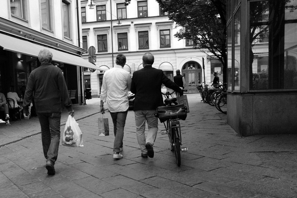 Gatebilde av tre menn sett bakfra